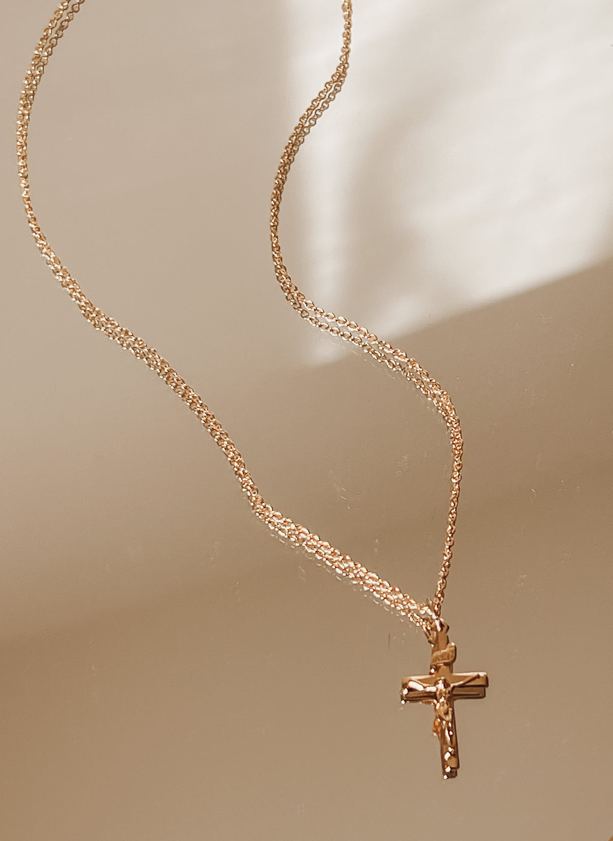 Gold filled Crucifix necklace On reflective background 